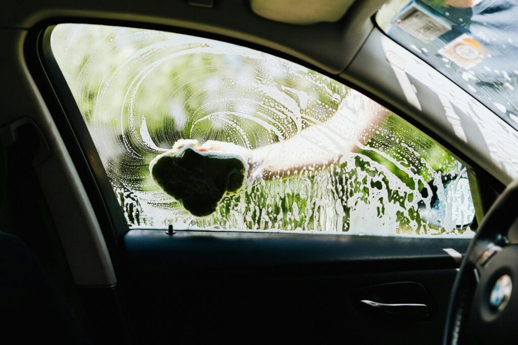 Windows being cleaned to properly clean a car
